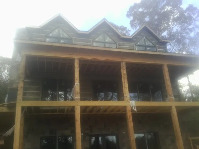 Dormers and porch framing on a large log home under construction — Roof Coating work by our crew in Penrose