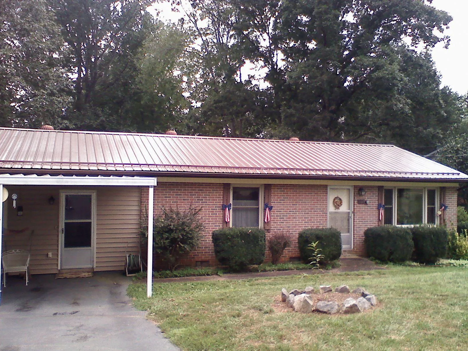 Bronze metal roof and carport on a brick ranch home — Roof Repair work by our crew in Penrose