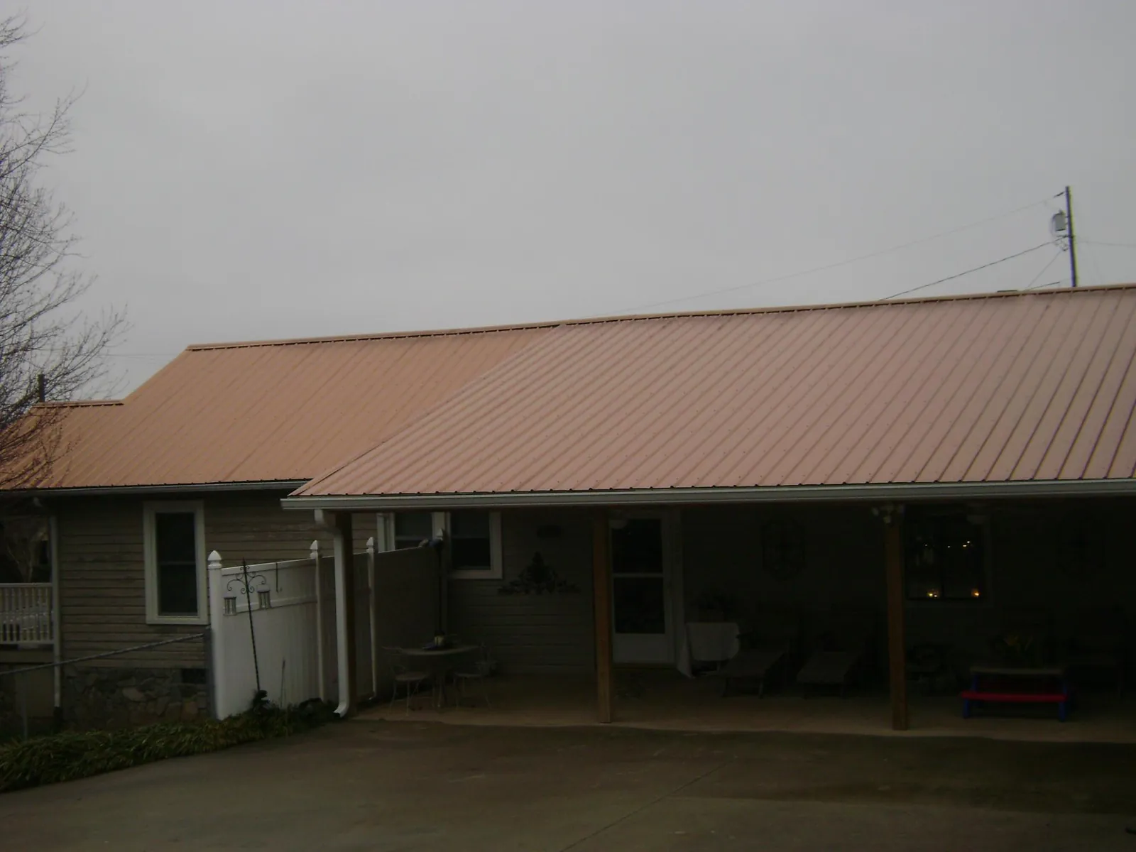 Copper toned metal roof over a wide covered patio in Penrose
